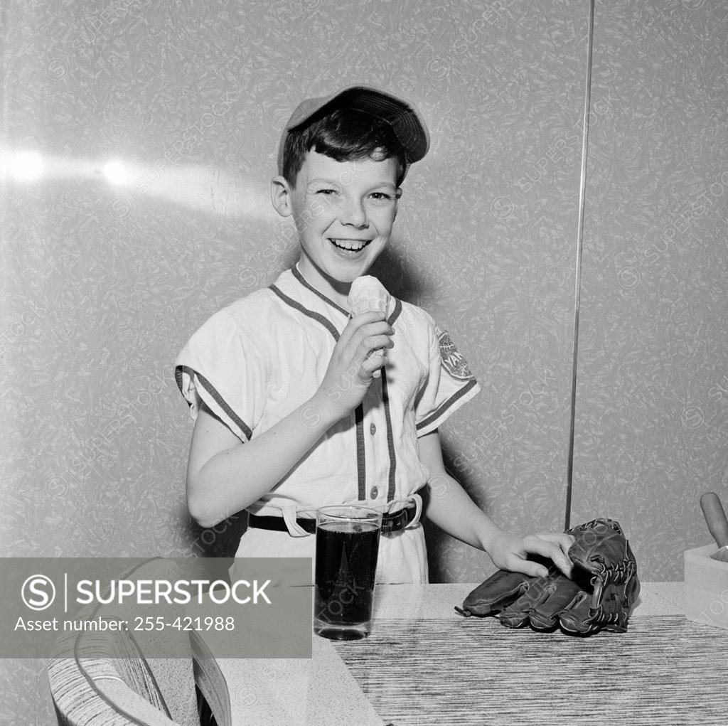 Stock Photo: 255-421988 Boy wearing baseball strip eating ice cream