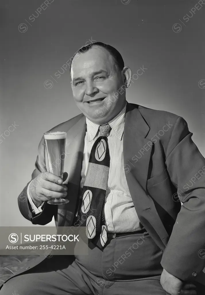 Portrait of mature man holding glass of beer
