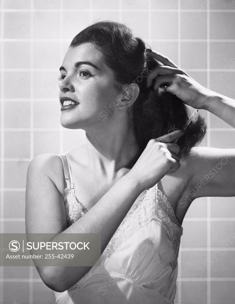 Stock Photo: 255-42439 Close-up of a young woman combing her hair