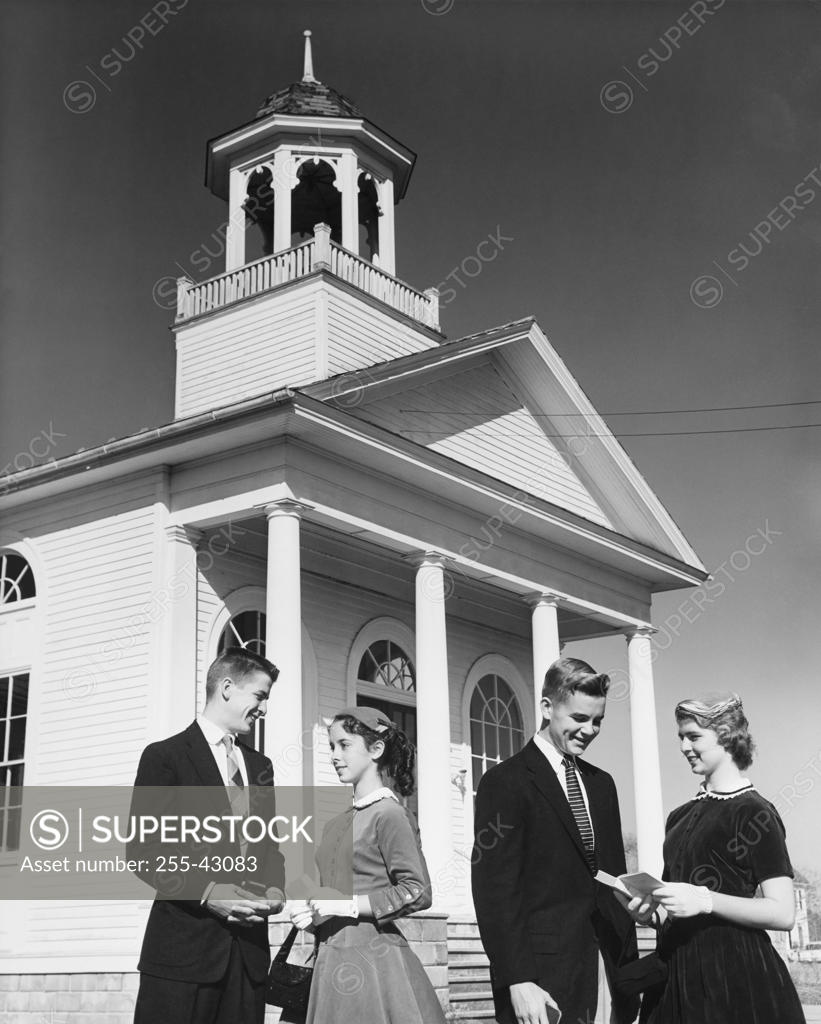 Stock Photo: 255-43083 Two young couples standing in front of a church