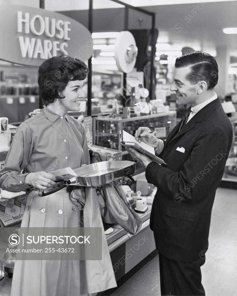 Stock Photo: 255-43672 Side profile of salesman and female customer smiling in store