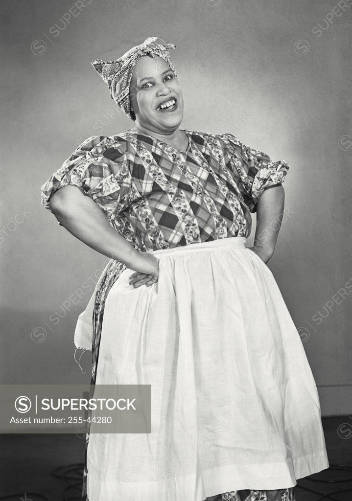 Stock Photo: 255-44280 Portrait of mid adult housewife smiling with her arms akimbo