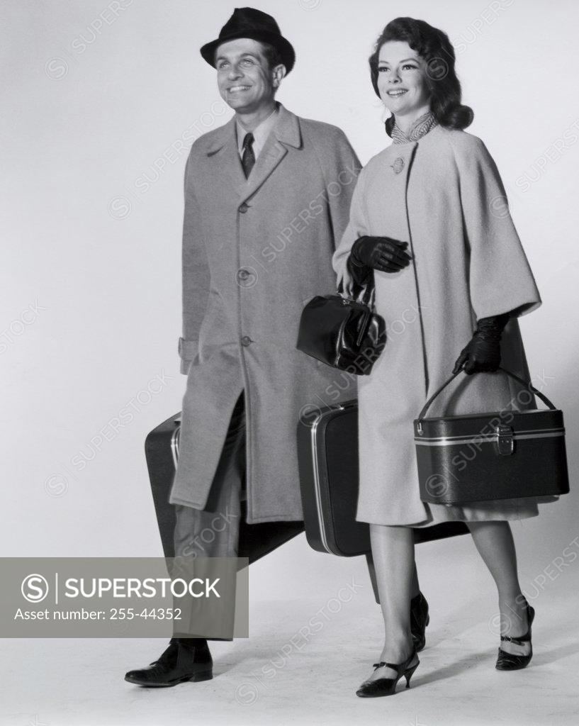 Stock Photo: 255-44352 Mid adult couple walking with luggage