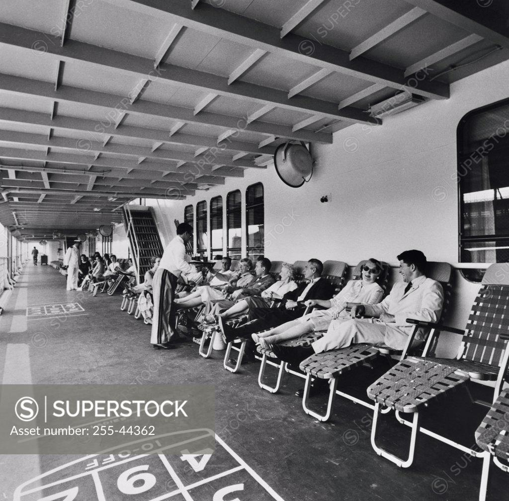 Stock Photo: 255-44362 Tourists reclining on lawn chairs on a cruise ship