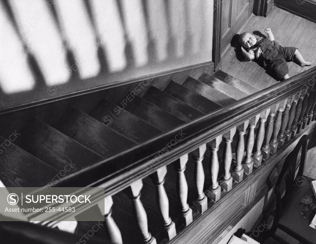 Stock Photo: 255-44583 High angle view of a baby lying near a staircase