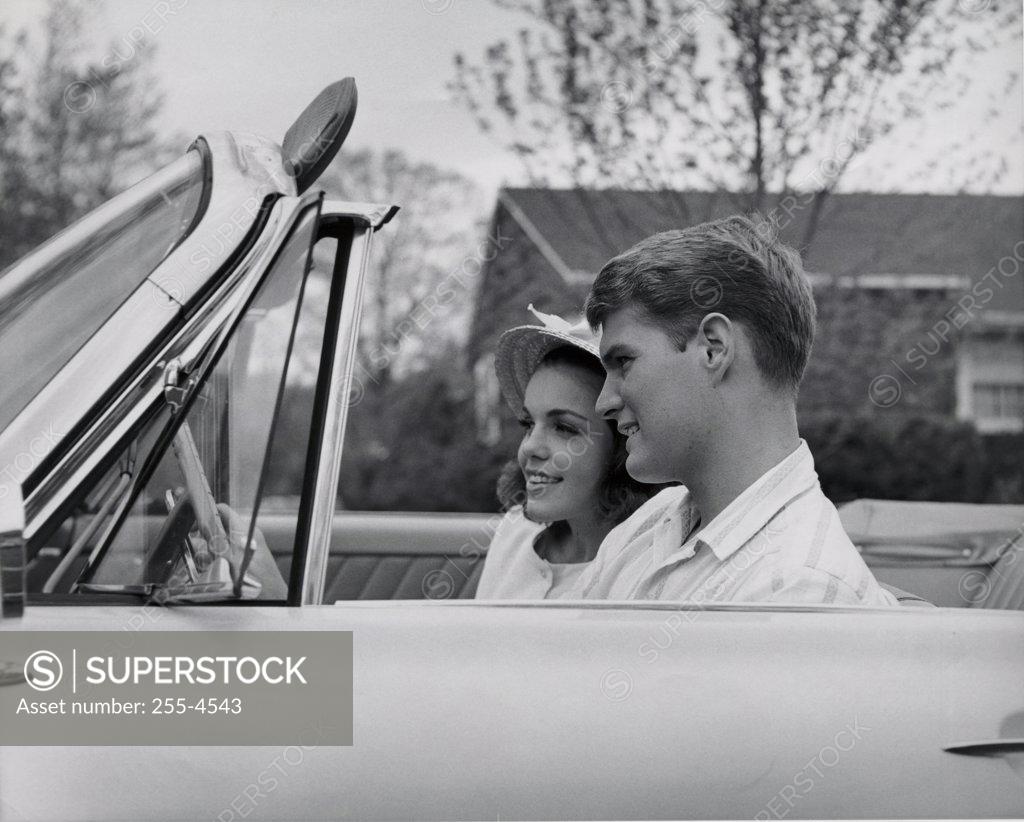 Stock Photo: 255-4543 Side profile of young couple sitting in convertible car