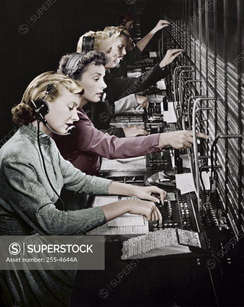 Stock Photo: 255-4644A Side profile of group of telephone operators operating switchboards