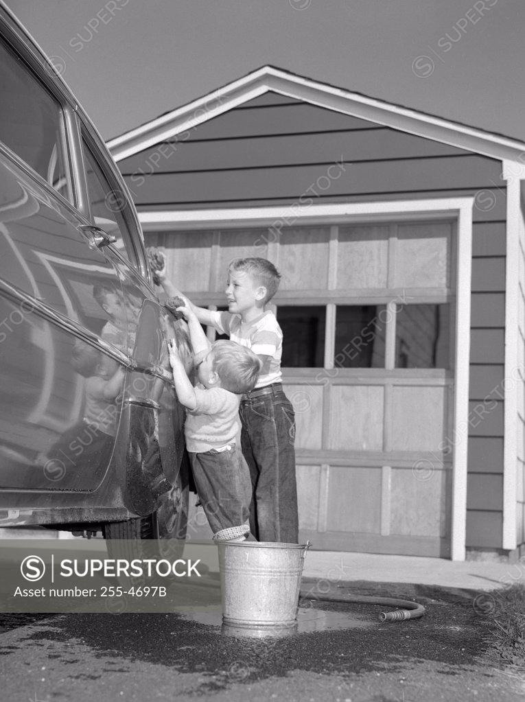 Stock Photo: 255-4697B Two boys cleaning car in front of house