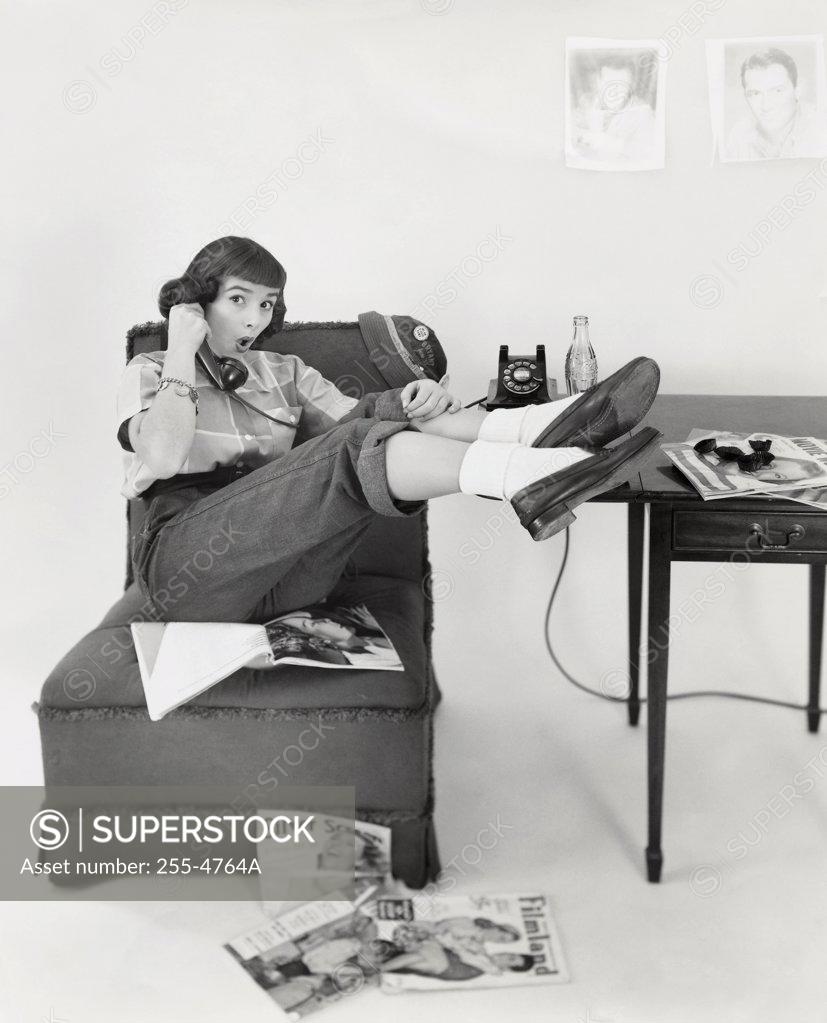 Stock Photo: 255-4764A Teenage girl sitting on a chair and talking on the phone