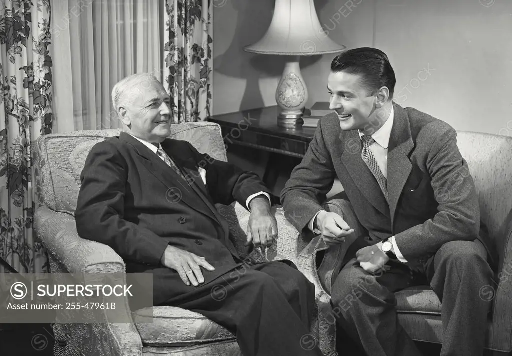 Young man and older man sitting together chatting