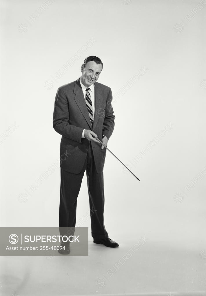 Stock Photo: 255-48094 Studio portrait of businessman pointing downwards with pointer stick