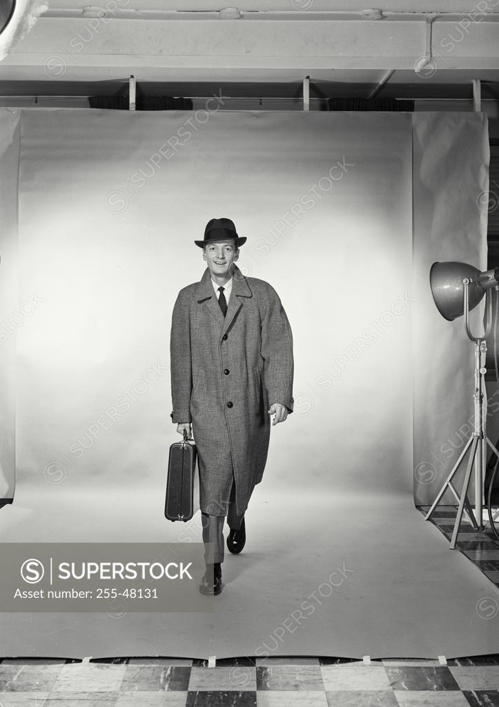 Stock Photo: 255-48131 Studio portrait of businessman carrying briefcase