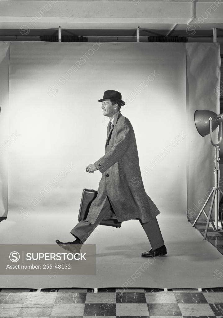 Stock Photo: 255-48132 Side profile of businessman carrying briefcase