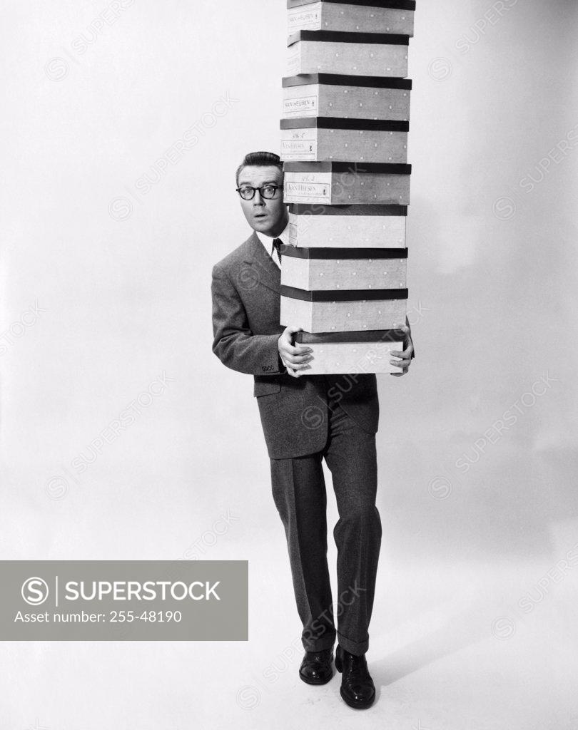 Stock Photo: 255-48190 Portrait of a businessman carrying a stack of boxes