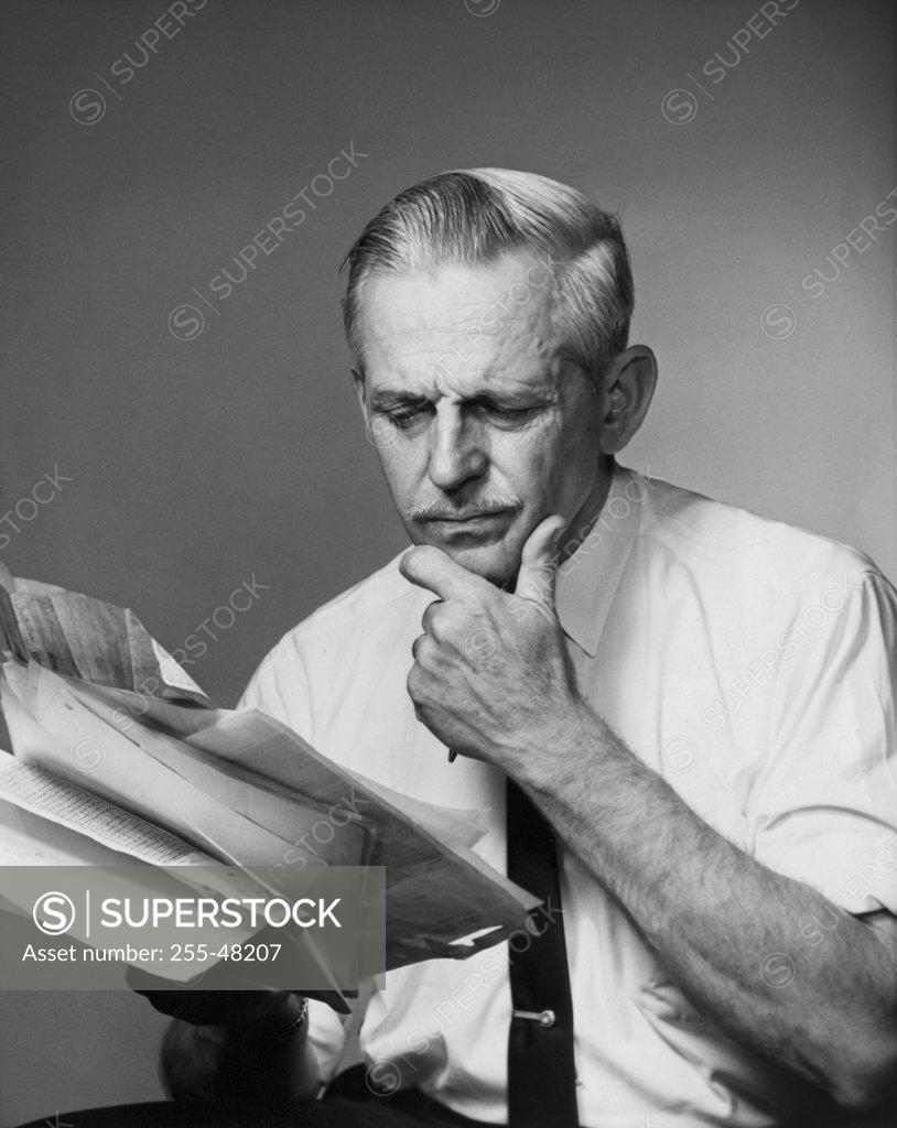 Stock Photo: 255-48207 Senior businessman reading documents