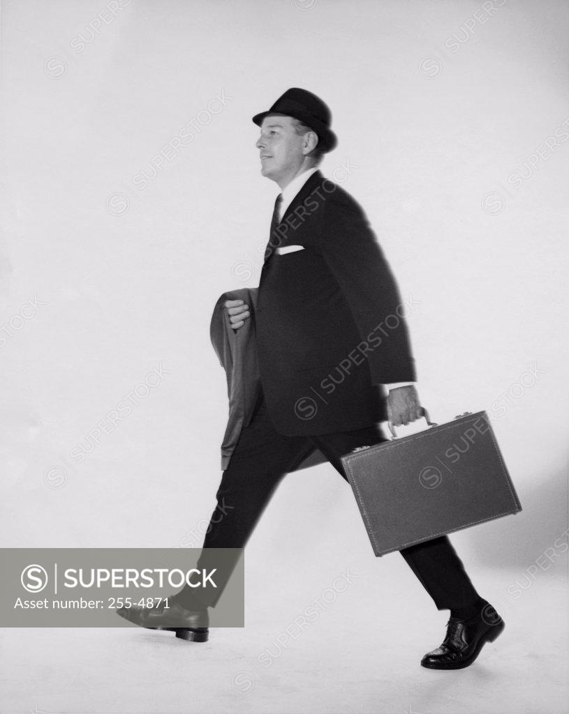 Stock Photo: 255-4871 Side profile of businessman carrying briefcase and an overcoat