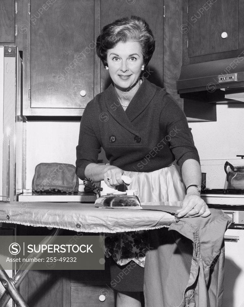 Stock Photo: 255-49232 Portrait of a mid adult woman ironing clothes