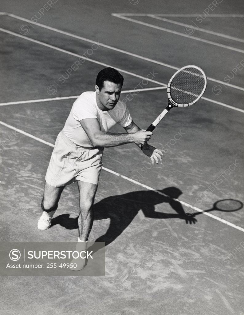 Stock Photo: 255-49950 Young man playing tennis on tennis court
