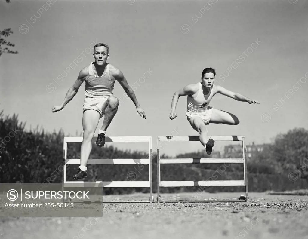 Vintage photograph. Runners jumping over hurdles.
