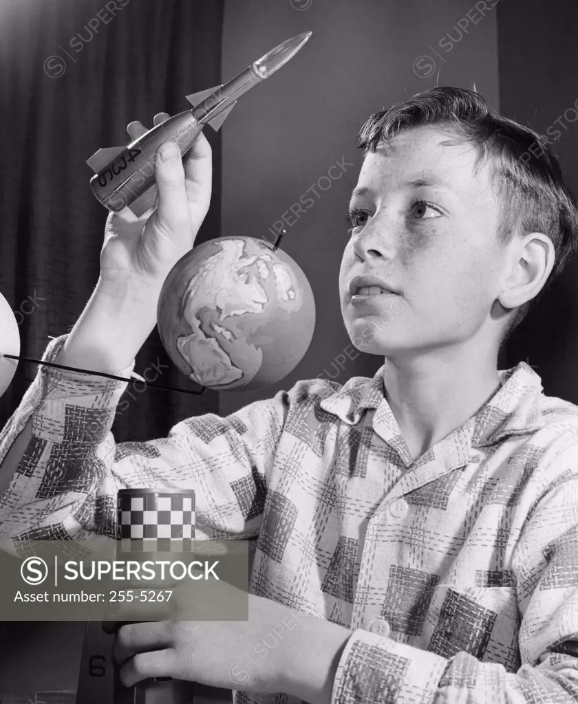 Close-up of a boy holding a model of a rocket