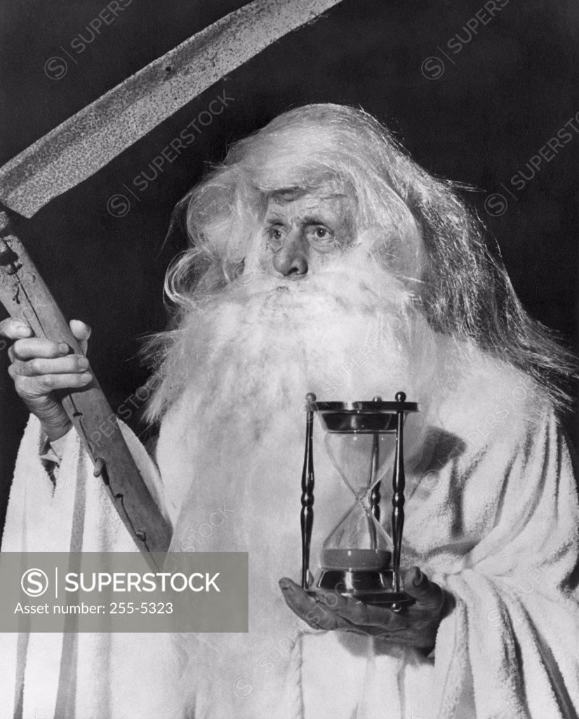 Stock Photo: 255-5323 Close-up of senior man holding hourglass and scythe