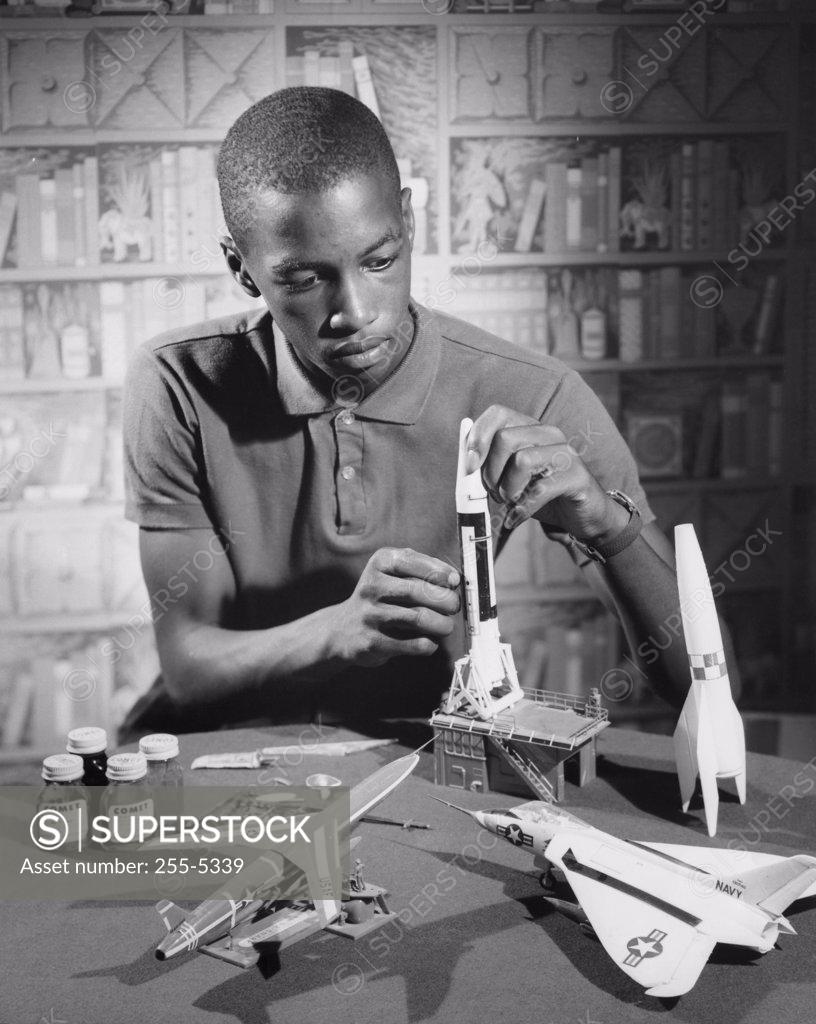 Stock Photo: 255-5339 Teenage boy making a model rocket, 1964