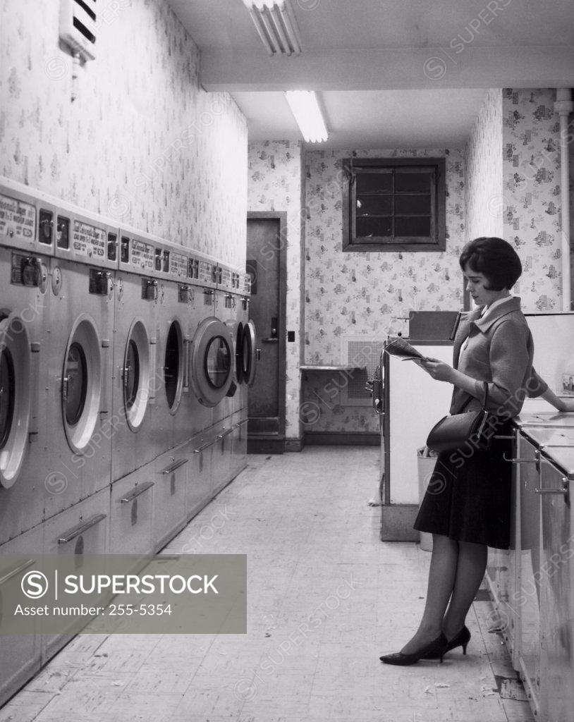 Stock Photo: 255-5354 Side profile of young woman standing in laundromat