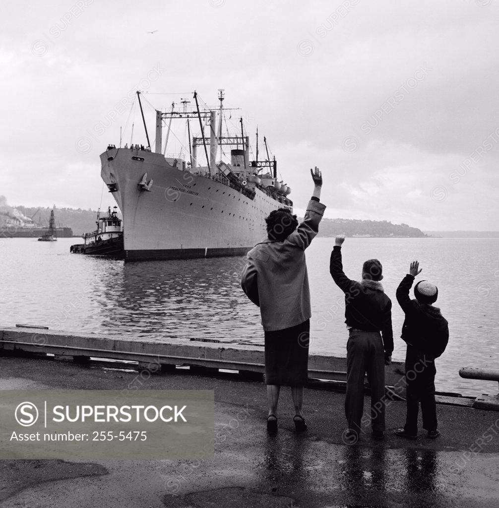 Stock Photo: 255-5475 Mother with two children waving to departing steamship