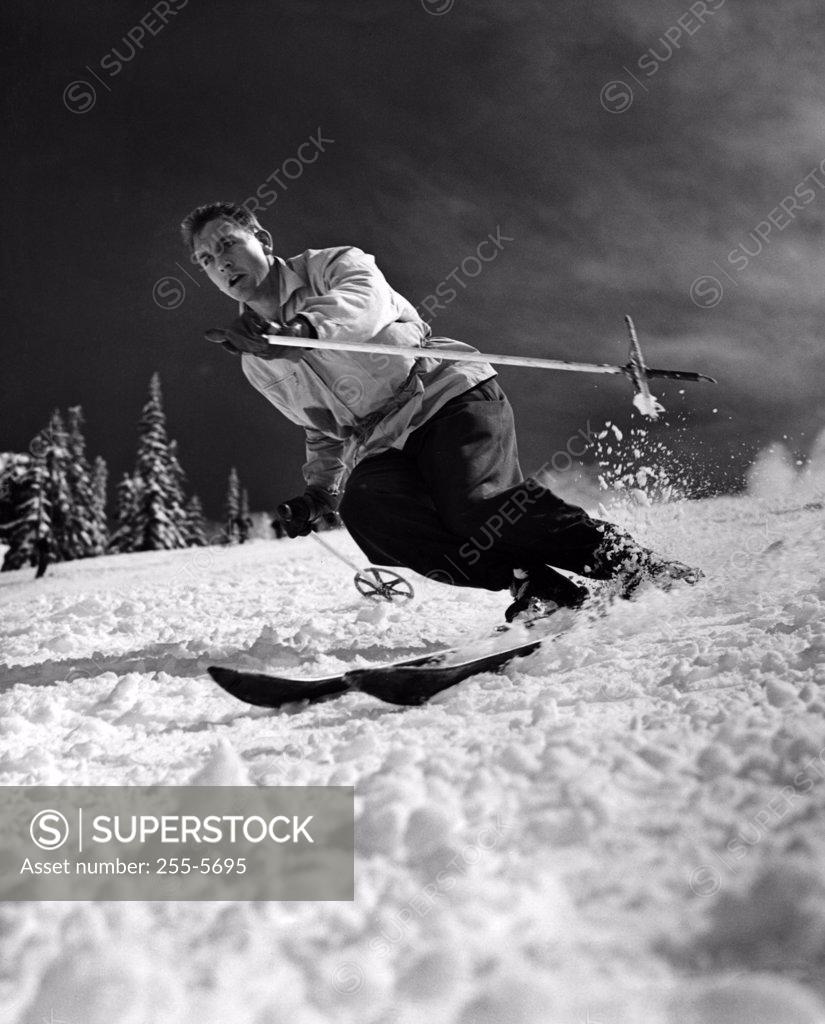 Stock Photo: 255-5695 Low angle view of a young man skiing downhill