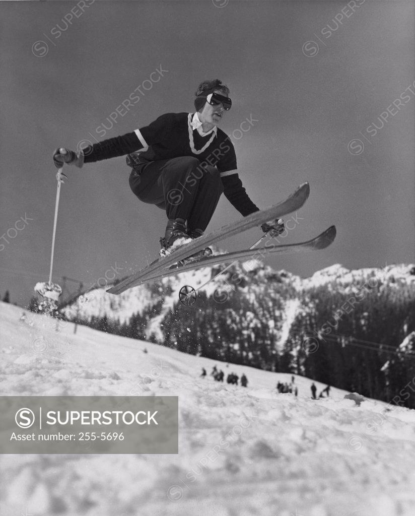 Stock Photo: 255-5696 Low angle view of young man skiing downhill