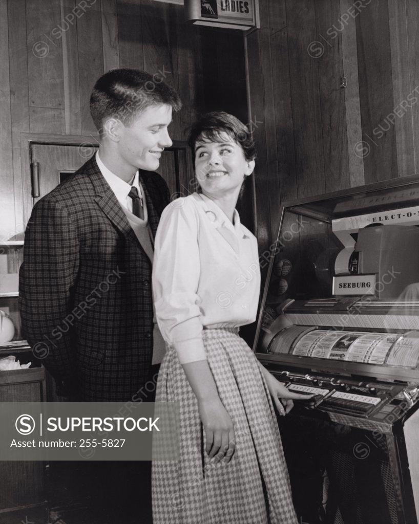 Stock Photo: 255-5827 Side profile of a teenage couple standing near a jukebox