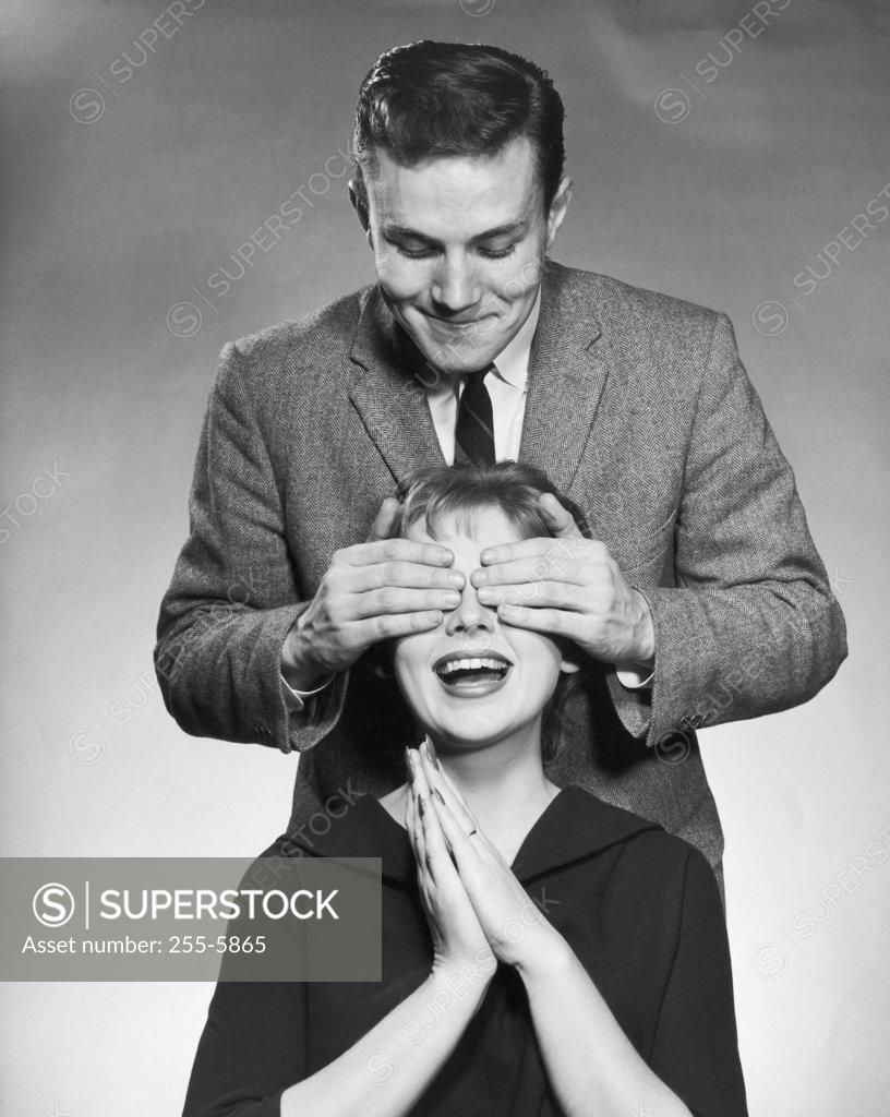 Stock Photo: 255-5865 Young man covering the eyes of a young woman from behind