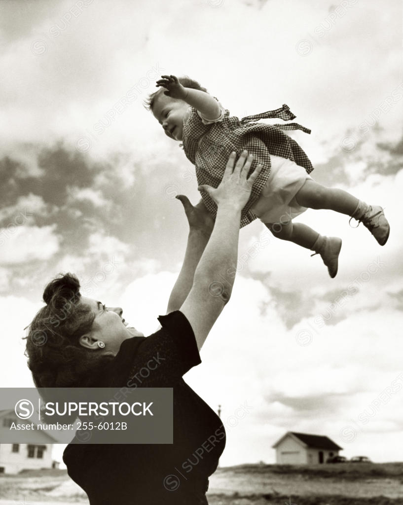 Stock Photo: 255-6012B Side profile of a mother tossing her daughter in the air