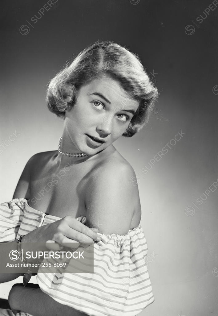 Stock Photo: 255-6059 Studio shot of young woman adjusting dress