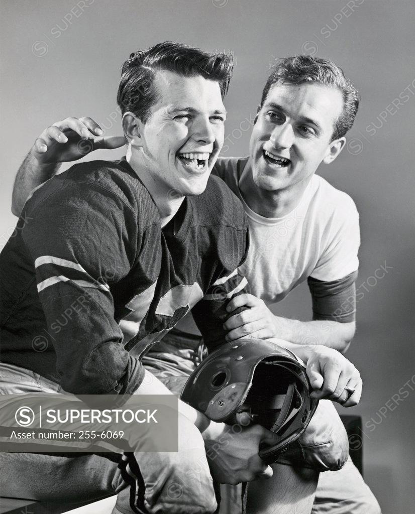 Stock Photo: 255-6069 Close-up of two football players sitting together and smiling