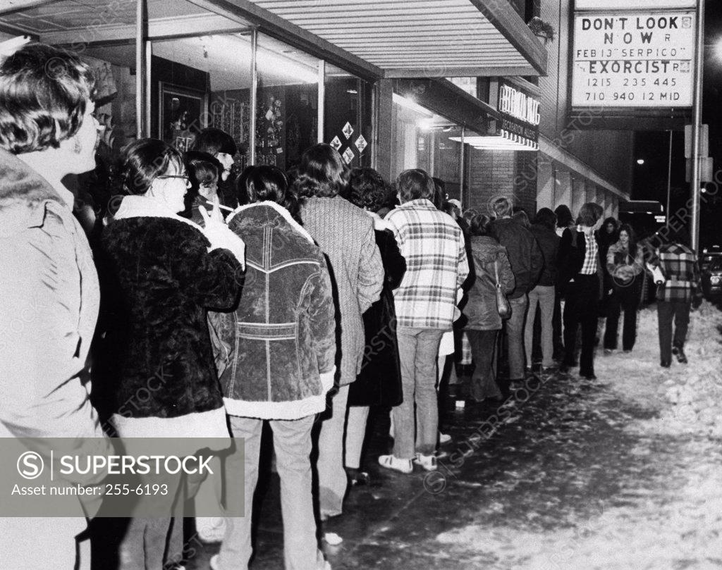 Stock Photo: 255-6193 Group of people standing in a row outside a movie theater