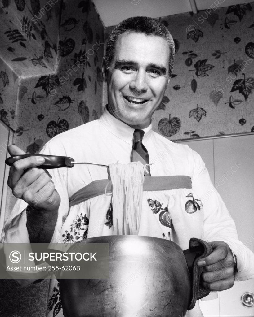 Stock Photo: 255-6206B Portrait of a chef holding cooked spaghetti using a fork