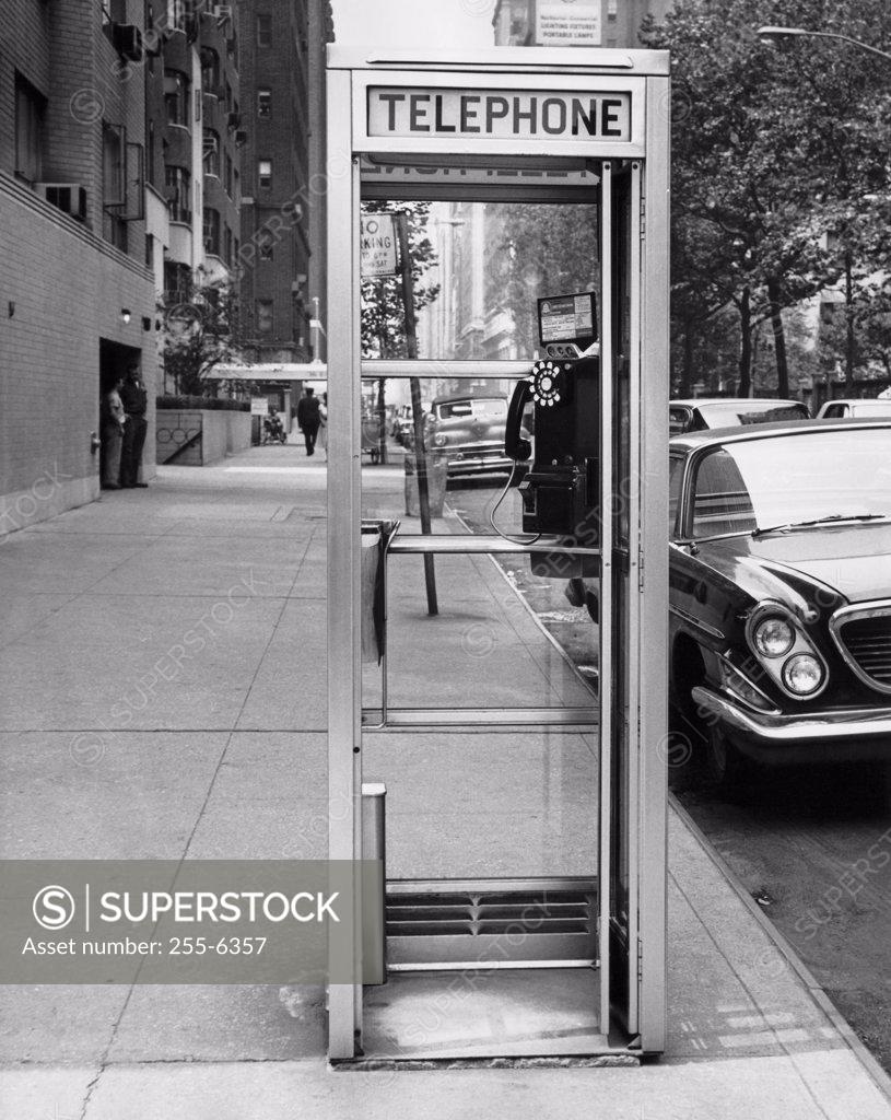 Stock Photo: 255-6357 Car parked at the side of a road near a telephone booth