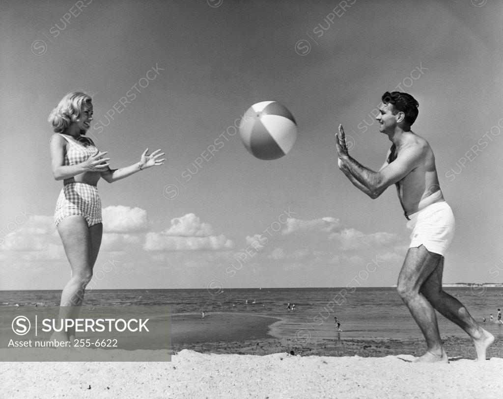 Stock Photo: 255-6622 Young couple playing with beach ball on beach