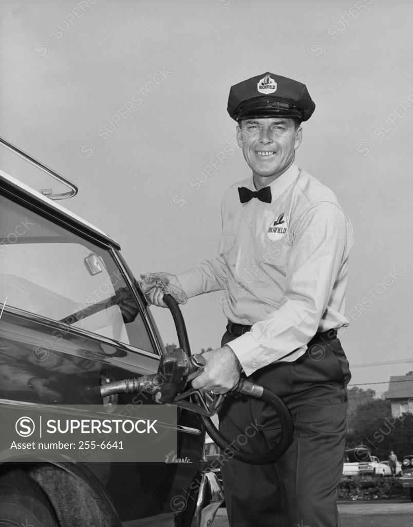 Stock Photo: 255-6641 Mid adult man refueling a car at a gas station