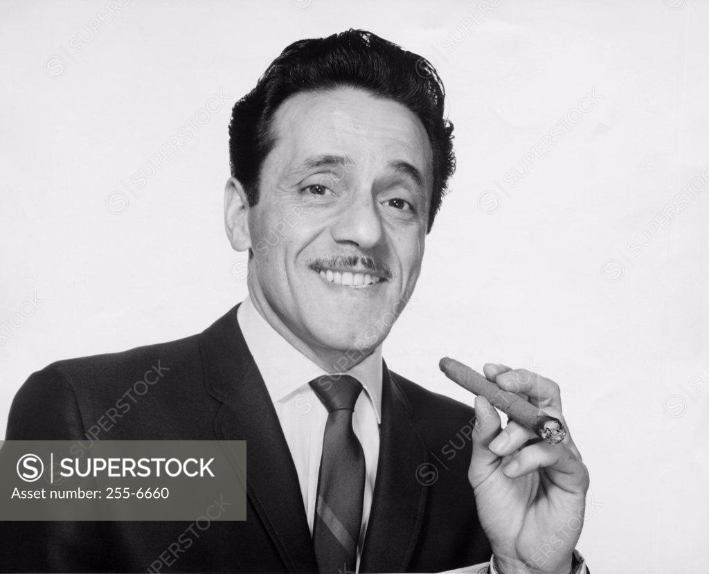 Stock Photo: 255-6660 Portrait of businessman holding cigar and smiling