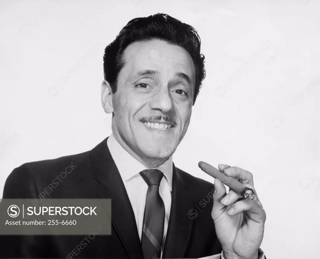 Portrait of businessman holding cigar and smiling