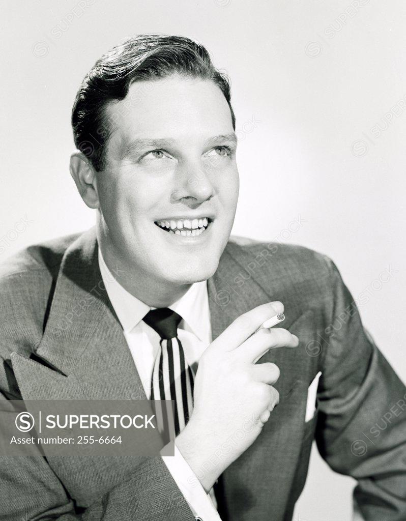 Stock Photo: 255-6664 Portrait of businessman holding cigarette and smiling