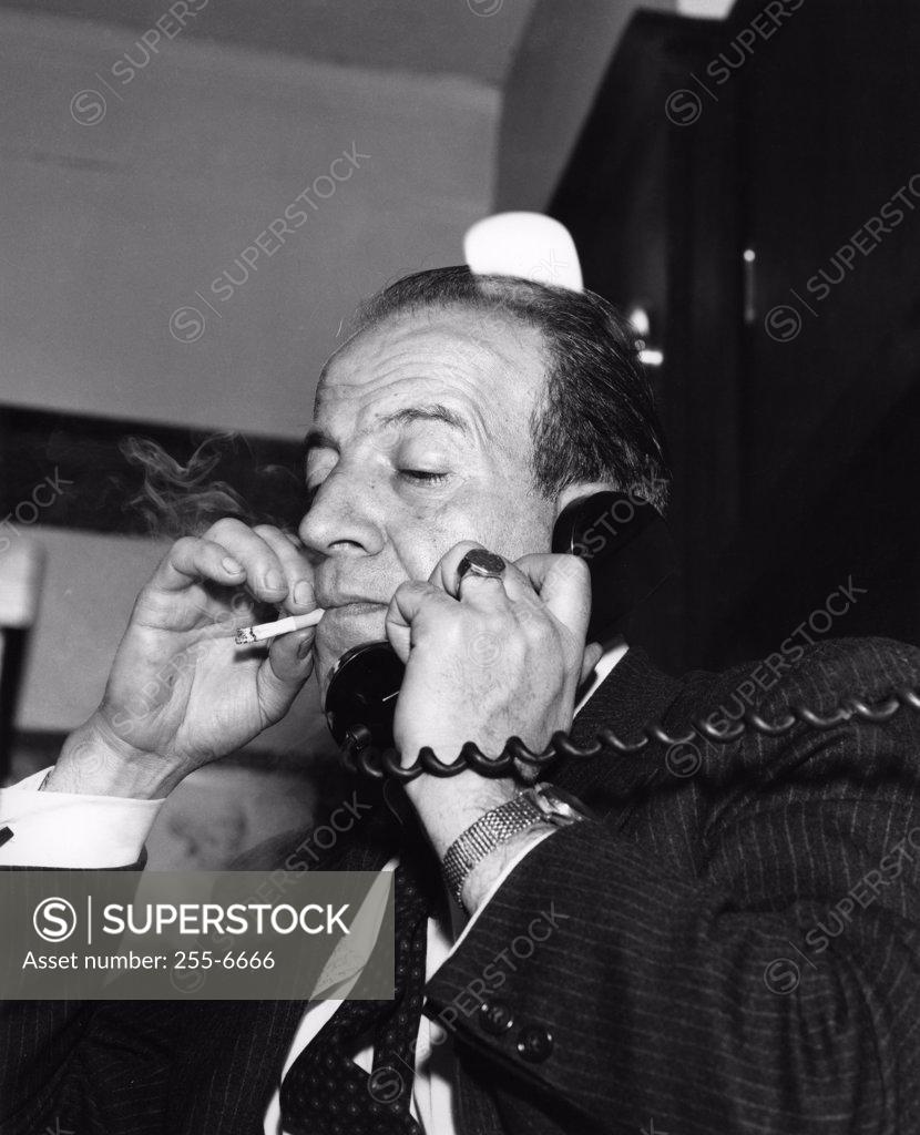 Stock Photo: 255-6666 Man with cigarette talking on phone