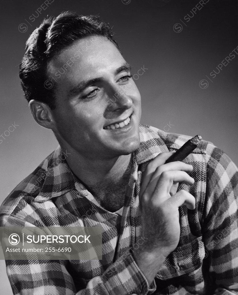 Stock Photo: 255-6690 Studio portrait of smiling man holding cigar