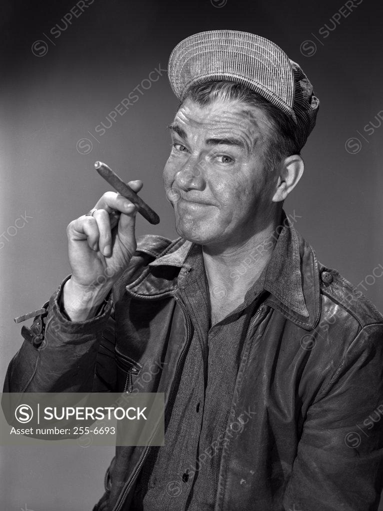 Stock Photo: 255-6693 Studio portrait of man smoking cigar