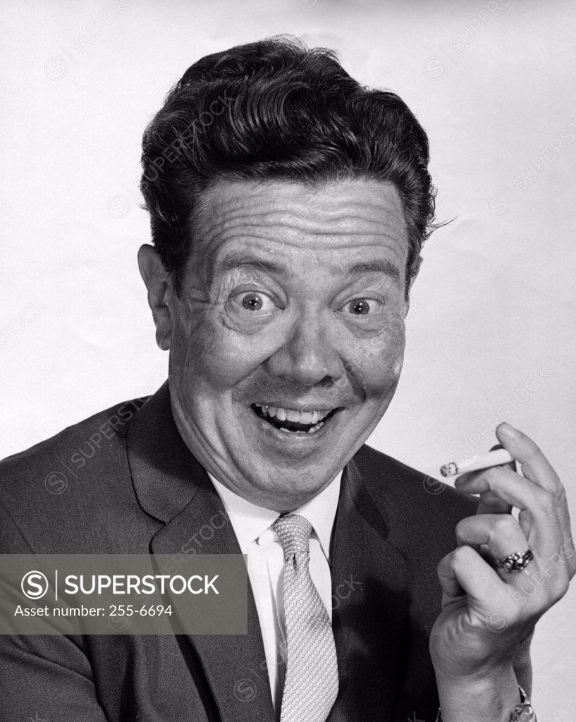 Stock Photo: 255-6694 Portrait of a mid adult man holding a cigarette