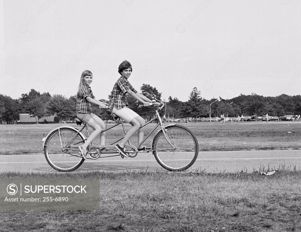 Stock Photo: 255-6890 Teenage boy and teenage girl riding a tandem bicycle