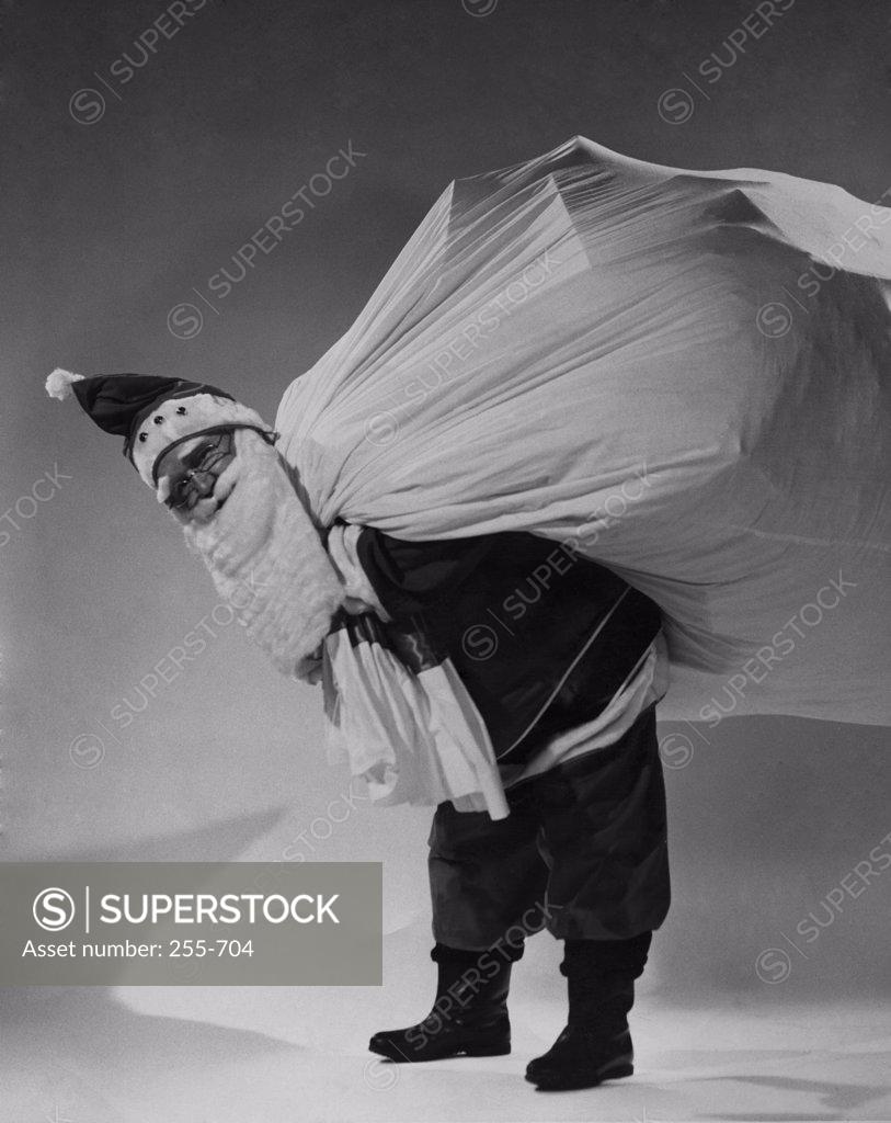 Stock Photo: 255-704 Portrait of Santa Claus carrying sack of gifts on his back