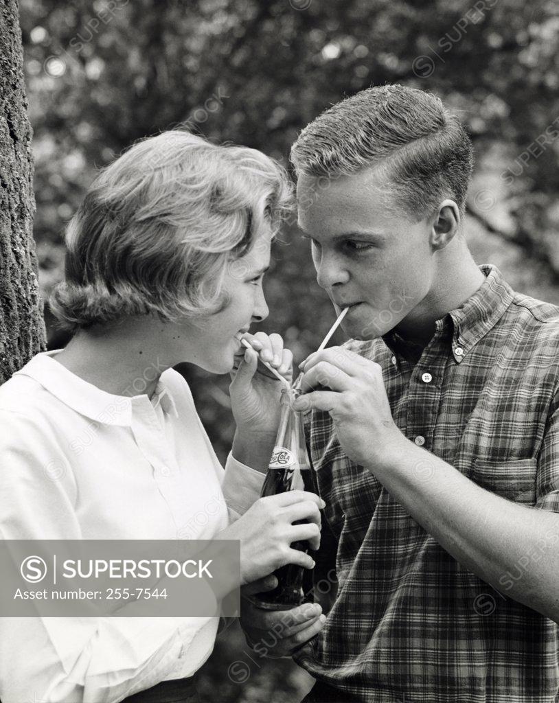 Stock Photo: 255-7544 Close-up of a teenage couple sharing a bottle of soda